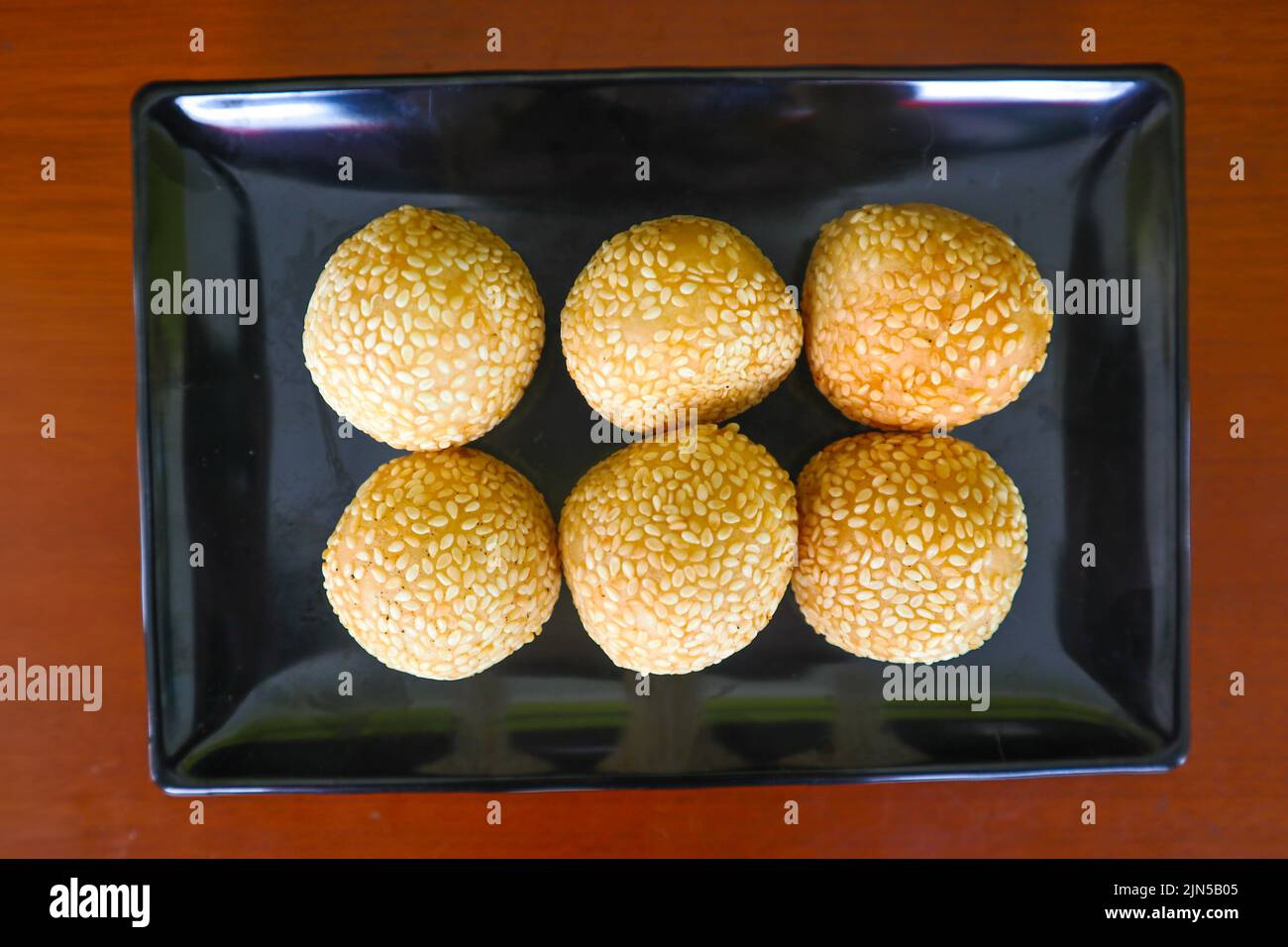 onde-onde o palla di sesamo o Jian Dui è una pasta fritta cinese fatta con farina di riso glutinoso e rivestita con semi di sesamo ripieni di pasta di fagioli. Foto Stock