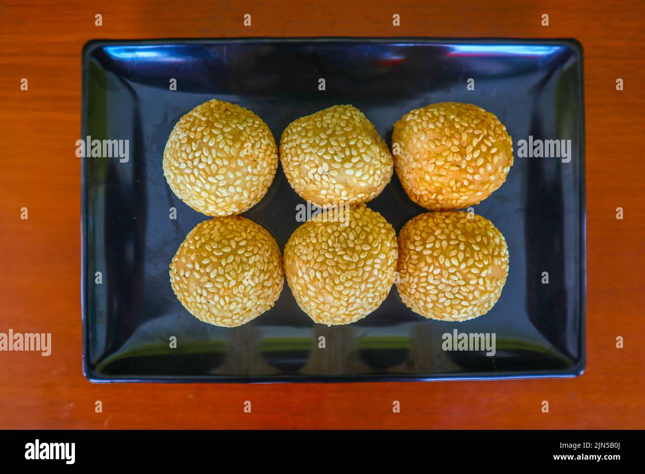 onde-onde o palla di sesamo o Jian Dui è una pasta fritta cinese fatta con farina di riso glutinoso e rivestita con semi di sesamo ripieni di pasta di fagioli. Foto Stock