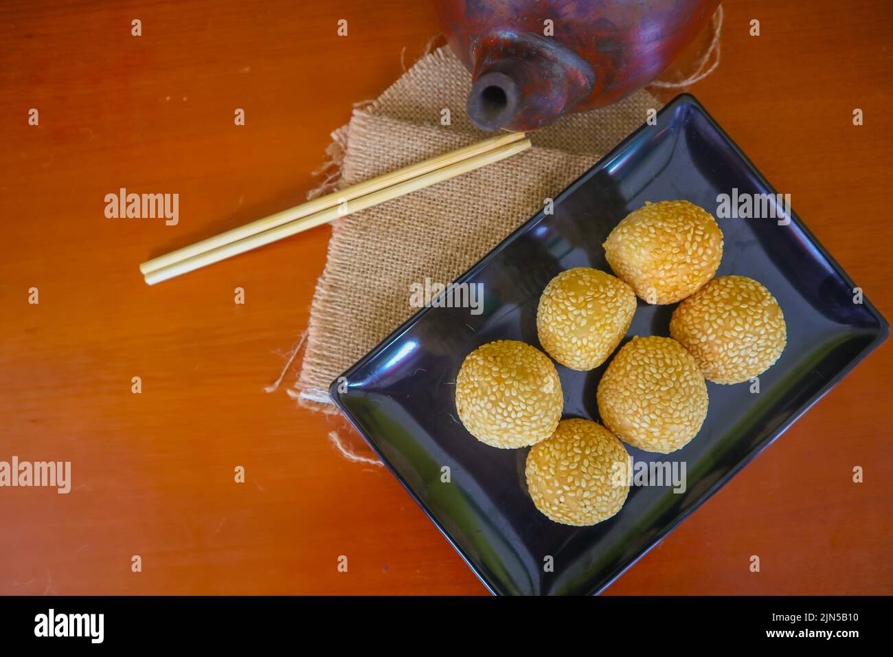onde-onde o palla di sesamo o Jian Dui è una pasta fritta cinese fatta con farina di riso glutinoso e rivestita con semi di sesamo ripieni di pasta di fagioli. Foto Stock