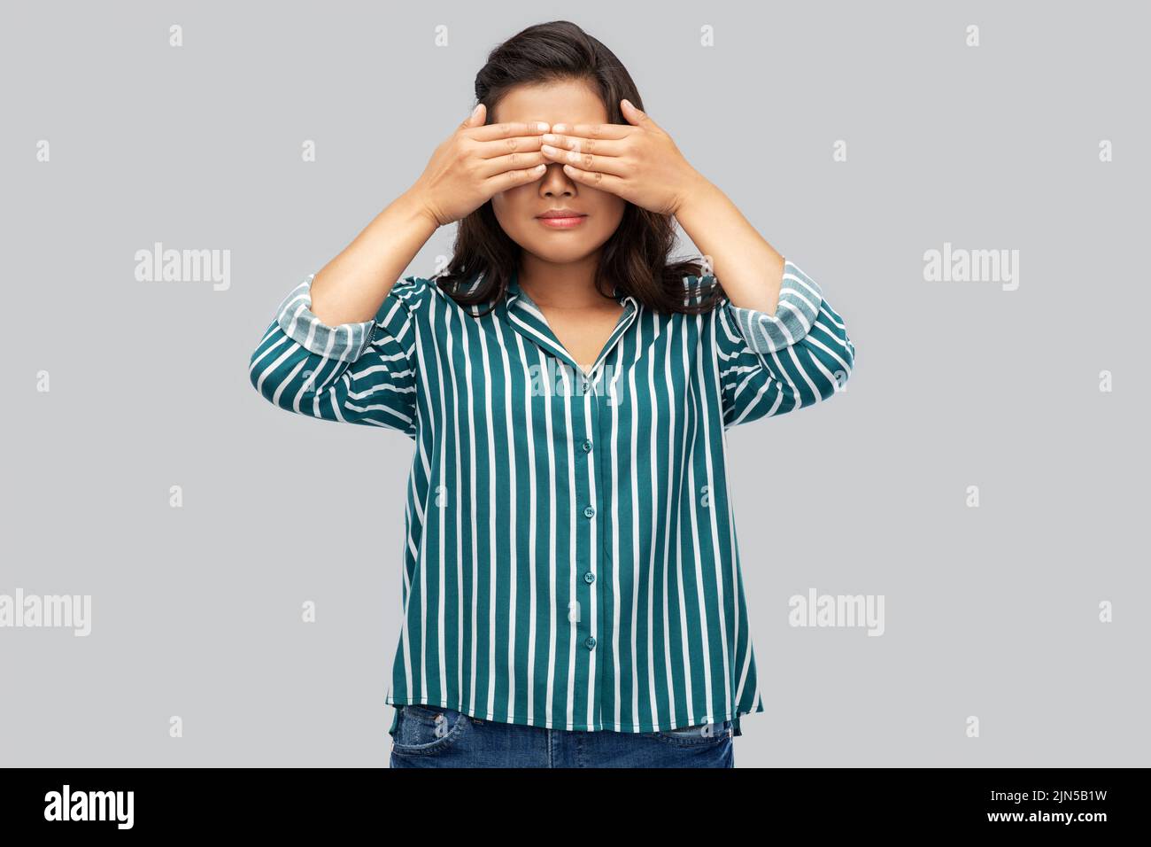 donna con gli occhi chiusi dalle mani Foto Stock