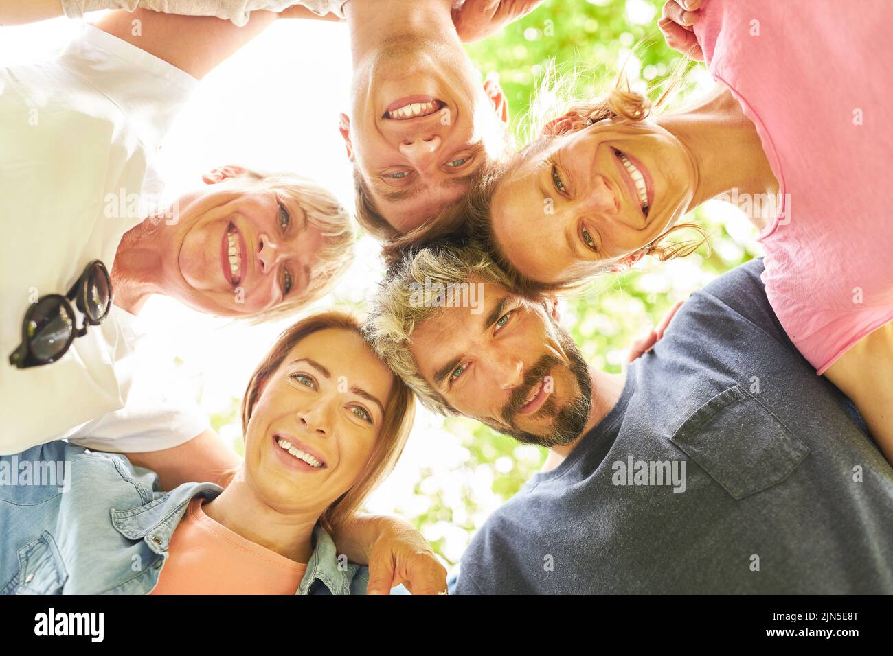 I giovani si riuniscono come una squadra in un cerchio di amicizia e comunità Foto Stock