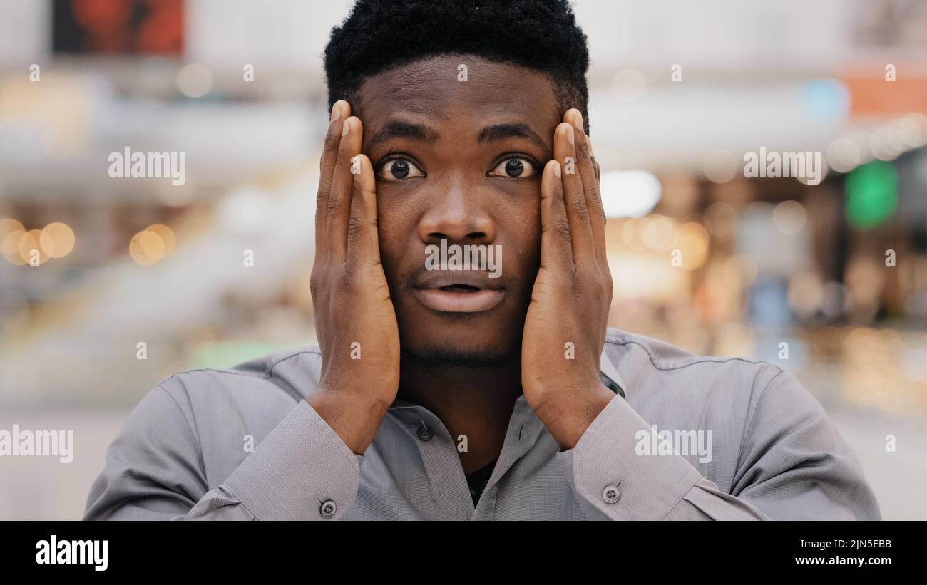 Primo piano ritratto maschile giovane sorpreso stupito eccitato scioccato grave afroamericano che tiene le mani sulla faccia sorpresa dicendo wow ottenere Foto Stock