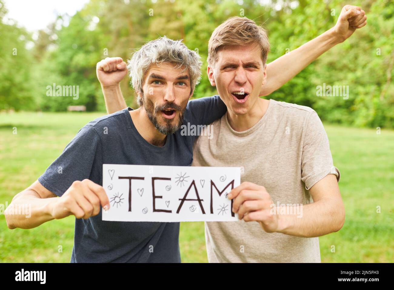 Due giovani uomini vincitori dell'evento sportivo all'aperto hanno firmato con la squadra come iscrizione Foto Stock