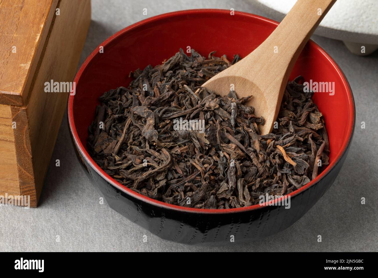 Ciotola con cinese pu EHR foglie di tè essiccato da vicino Foto Stock