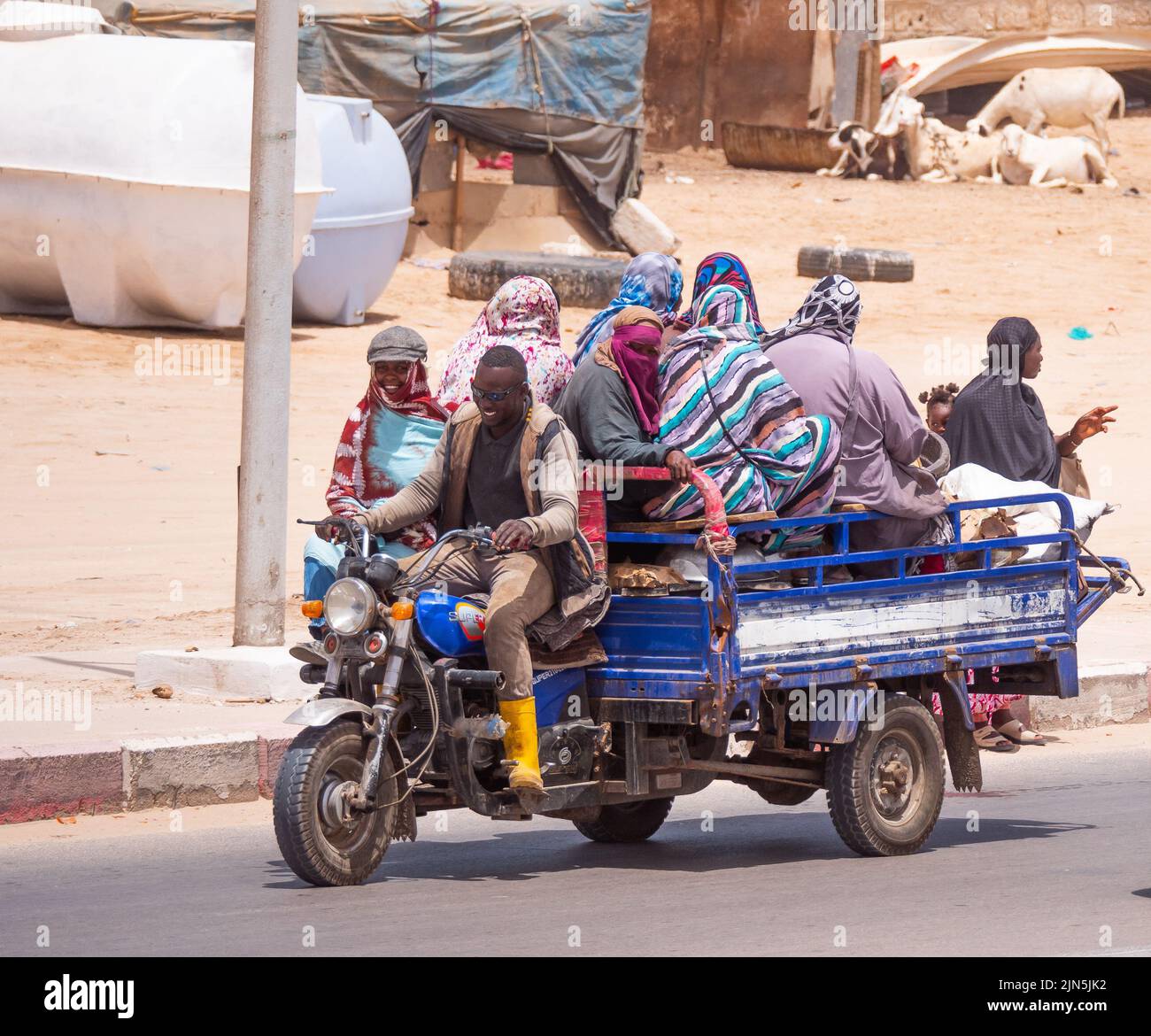 Un trezzolo di viaggio lungo una strada che trasporta molte persone. La città è Nouakchott, Mauritania. Foto Stock