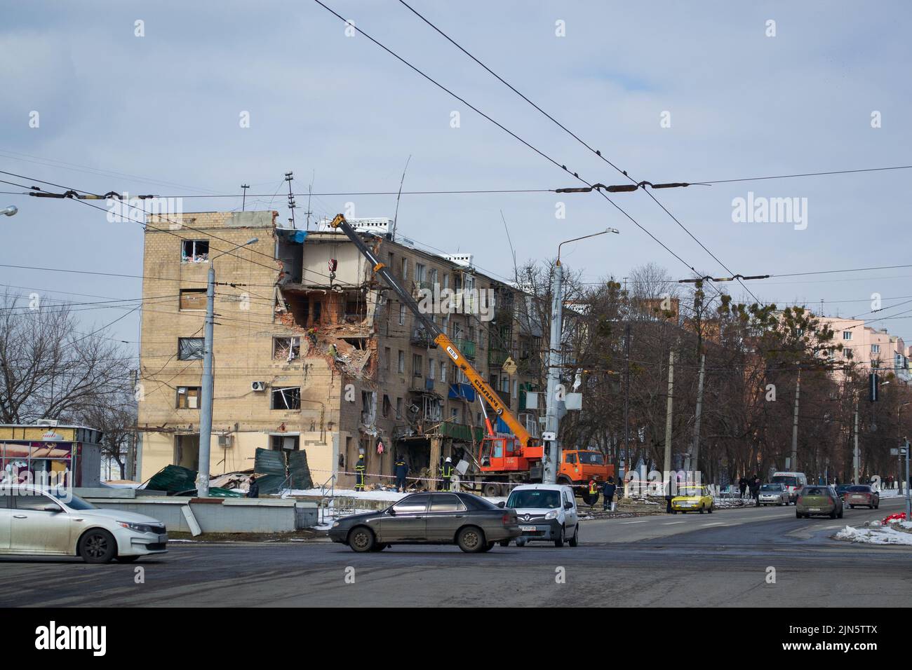 Kharkiv, Kharkov, Ucraina - 05.28.2022: Casa bombardata in Ucraina gru di città smantellamento distrutto edificio residenziale circondato veicolo civile Foto Stock