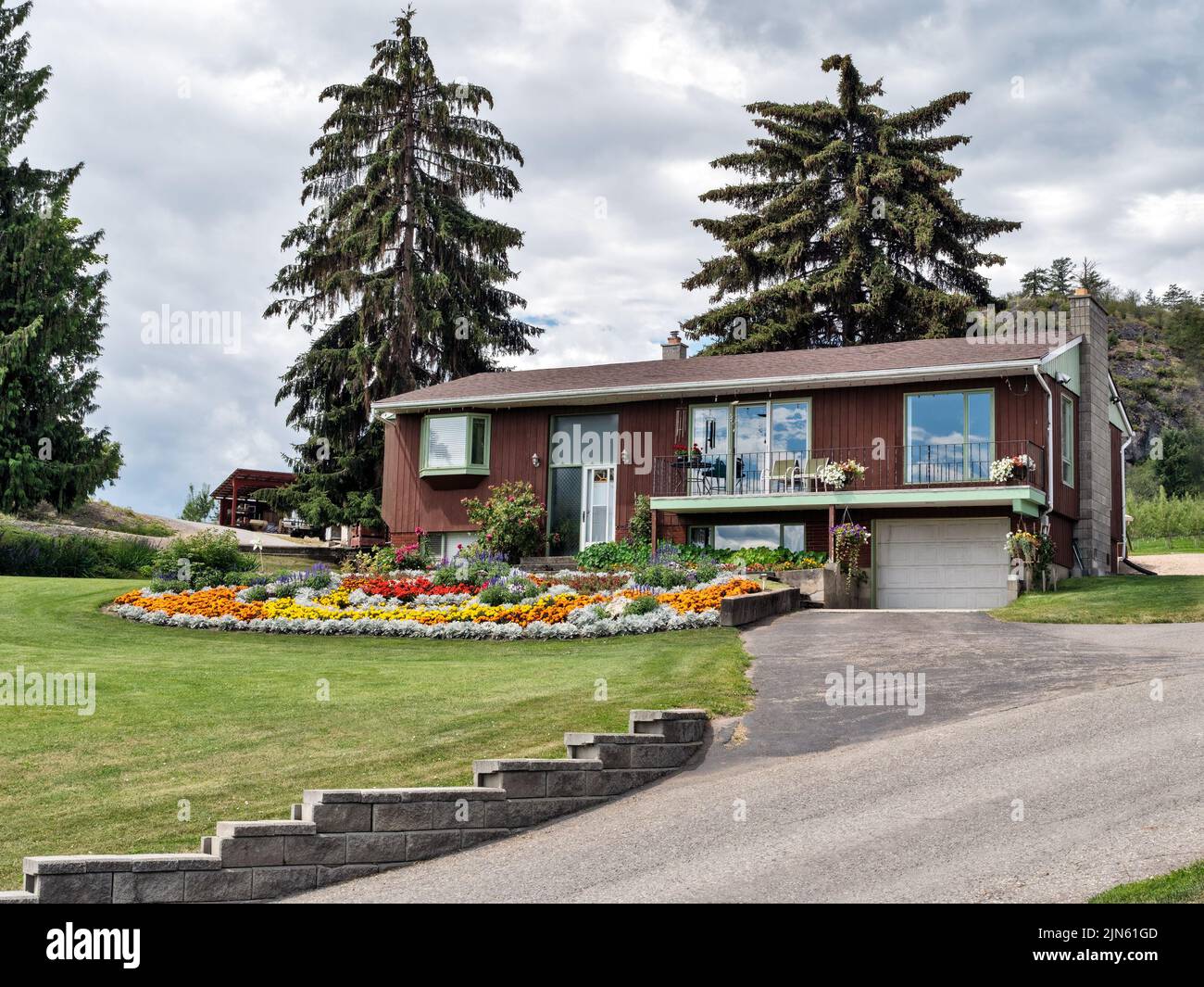 Vecchia casa residenziale in Canada con grande letto di fiori sul cortile anteriore Foto Stock