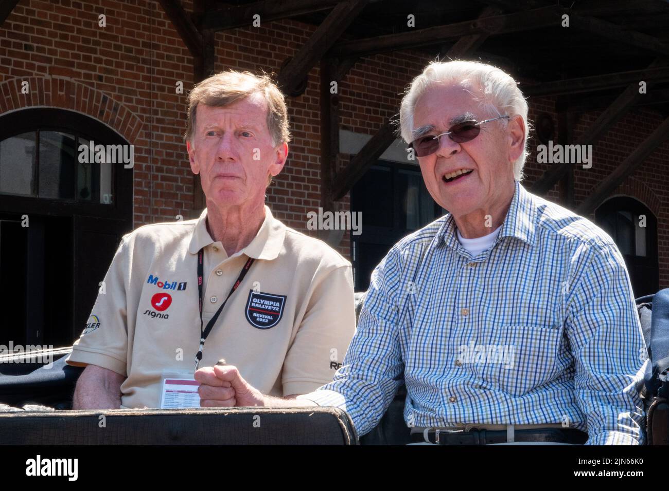 09 agosto 2022, bassa Sassonia, Einbeck: Ex campione del mondo di rally Walter Röhrl (l) prende una lezione di guida dal collettore di auto e moto Karl-Heinz Rehkopf sulla più vecchia automobile registrata del mondo, un Benz Victoria No. 99 costruito nel 1894 (ancora dal video dpa). Röhrl fermato dalla PS Speicher con il Rally Olimpico '72 Revival 2022 con oltre 200 vetture classiche, che corre da Kiel a Monaco e ricrea il Rally Olimpico 1972, e ha preso la lezione di guida speciale. Foto: Melissa Erichsen/dpa Foto Stock