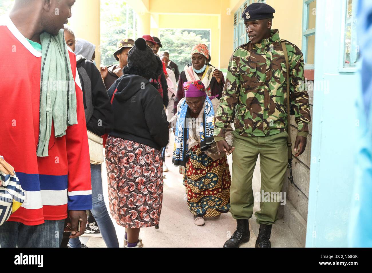 Nakuru, Kenya. 09th ago 2022. Polizia Constable, Gilbert Langat, 32, aiuta Esther Thira, 77, Accedi all'area di scrutinio del centro di scrutinio della Nakuru Boys High School nella circoscrizione di Nakuru Town East durante le elezioni generali del Kenya. I keniani hanno iniziato a votare martedì mattina, 9 agosto 2022, per eleggere il loro presidente preferito e i membri delle assemblee nazionali e di contea. (Foto di James Wakibia/SOPA Images/Sipa USA) Credit: Sipa USA/Alamy Live News Foto Stock