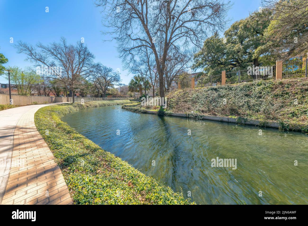 Piccolo fiume a San Antonio, Texas, con passerella in cemento con percorso curvo Foto Stock