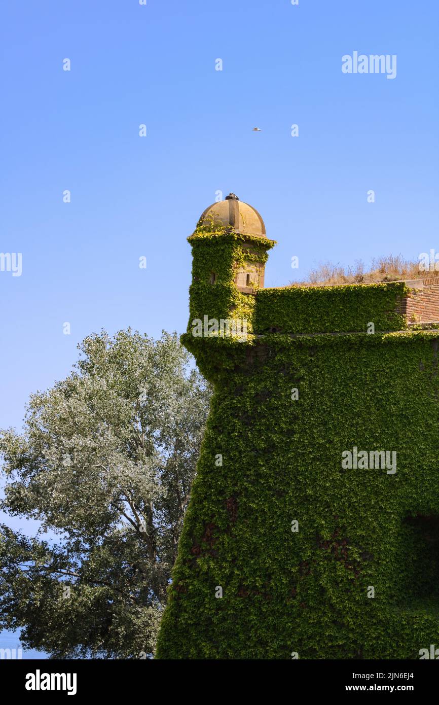 Foto verticale di una parte del castello nel Parco Montjuic, Barcellona, Spagna con uno sfondo di cielo e mare Foto Stock