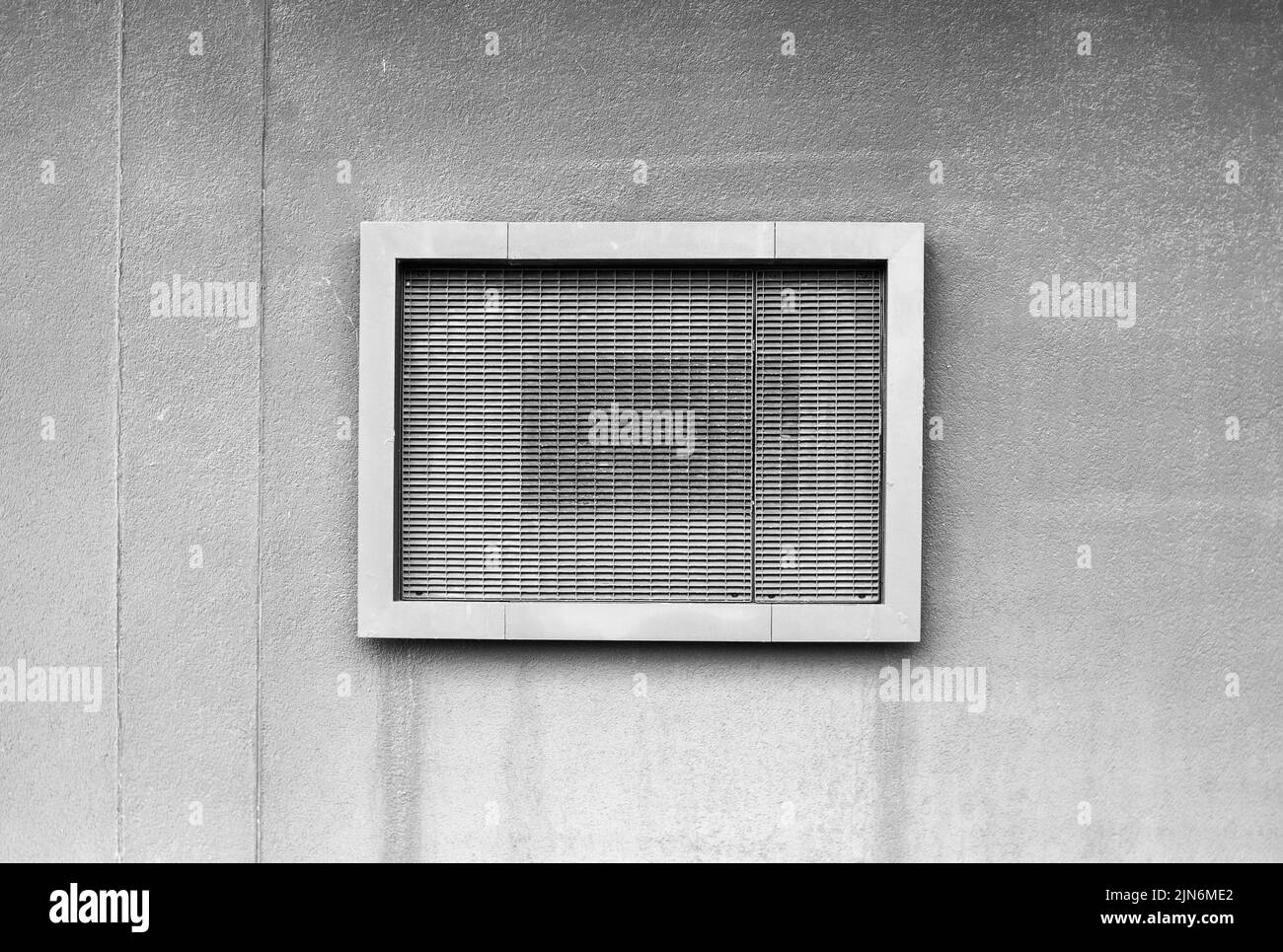 Immagine in bianco e nero di una griglia di ventilazione rettangolare su una parete metallica. Foto Stock