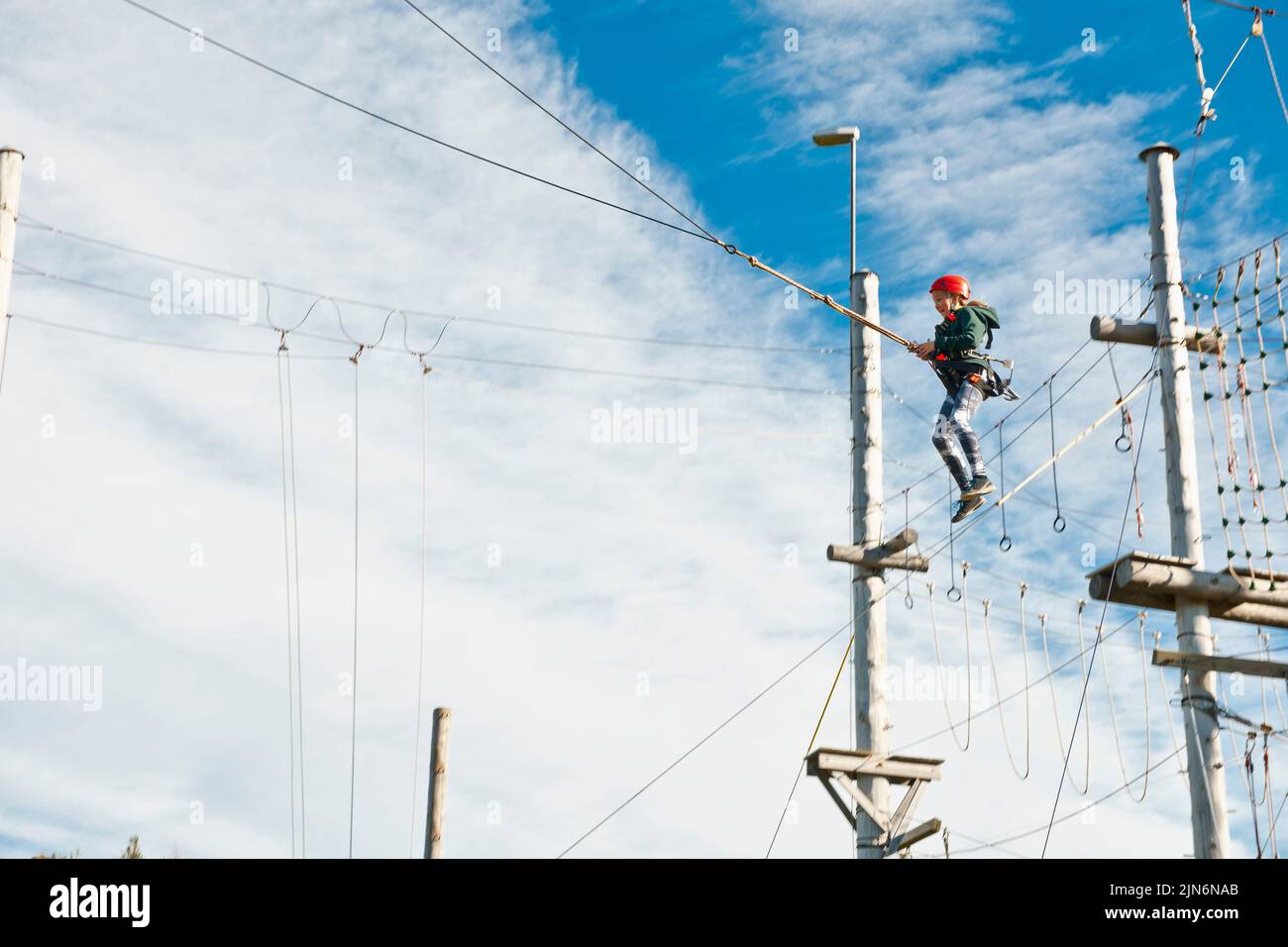 Ragazza che usa un'altalena gigante al corso di accesso ad alta corda in Islanda Foto Stock