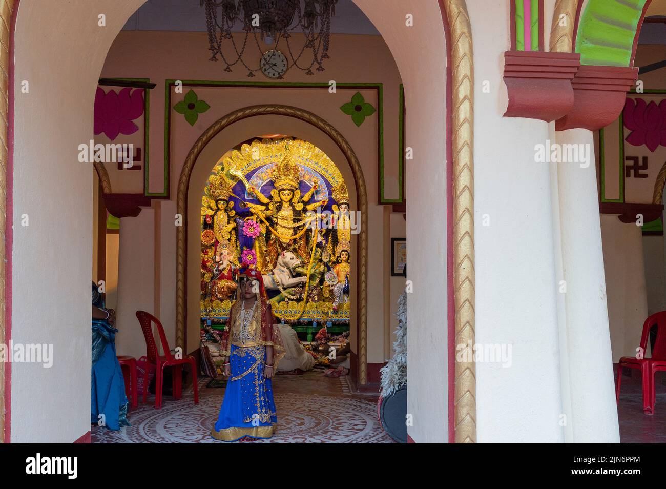 Howrah,India -26th ottobre 2020 : ragazza bengalese bambino in posa con la Dea Durga in background, all'interno di una casa decorata in età avanzata. Durga Puja festival. Foto Stock