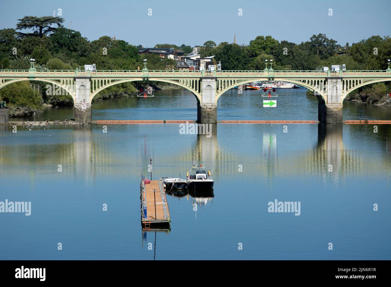 il fiume tamigi guarda a nord dal ponte di twickenham verso il ponte pedonale richmond lock con il molo del padrone del porto e le navi in primo piano. Foto Stock