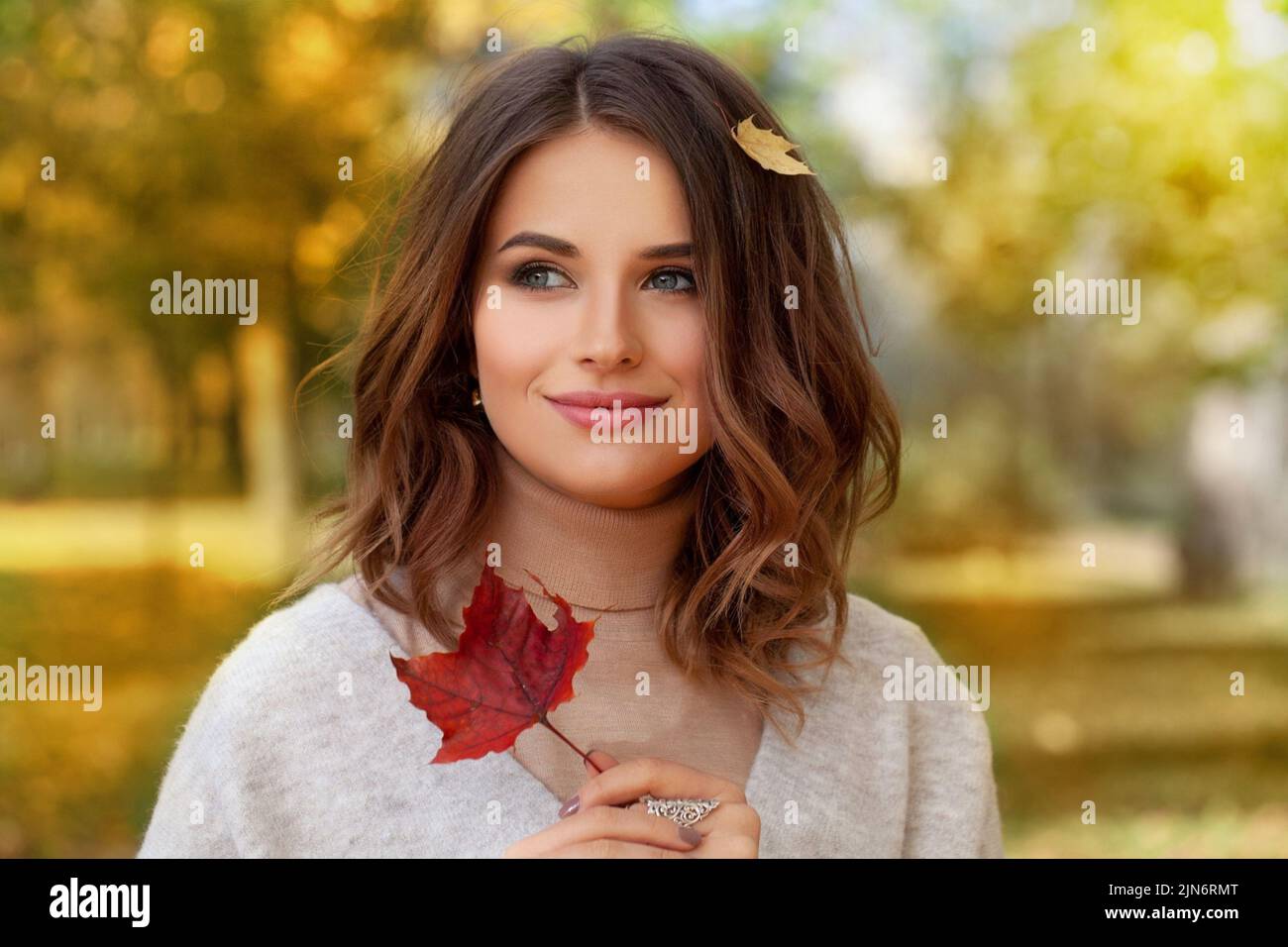 Foto di moda esterna suggestiva di giovane donna attraente con lonh bob acconciatura in autunno paesaggio Foto Stock