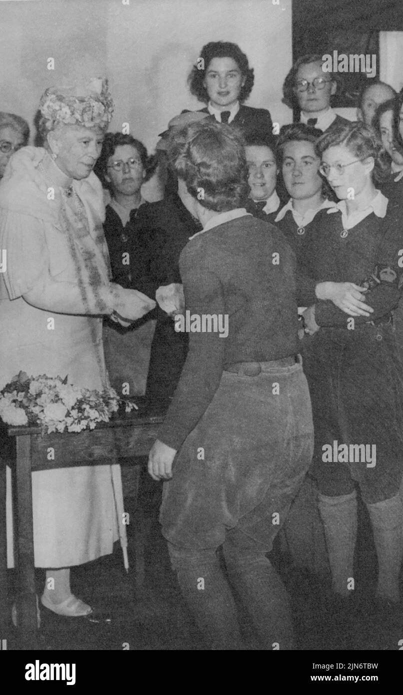 Queen Mary visita Land Girls -- Queen Mary che presenta buoni Diamanti di servizio. La Regina Maria ha visitato il Womens Land Army Hostel a ***** Vicino Chipping Campden, Glos, e ha presentato buoni Diamanti di servizio alle ragazze di terra che hanno lavorato sulla terra efficientemente per 6 mesi. L'ostello è gestito dal Gloucestershire War Agricultural Committee ed è una moderna Cotswold House del 16th secolo. Maggio 25, 1943. (Foto di Fox Photos). Foto Stock