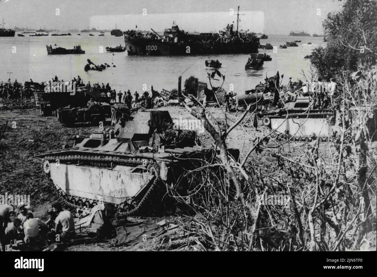 I rinforzi raggiungono Okinawa: Gli uomini e le attrezzature americane vengono a terra a Okinawa, isola giapponese Ryukyu, a 375 miglia da Kyushu, isola giapponese. Una LST attende di scaricare il proprio carico, mentre la spiaggia è una scena di attività febbrile, mentre le forze americane si preparano a muoversi verso l'interno per rafforzare le forze americane impegnate nei combattimenti più sanguinosi mai visti nella campagna del Pacifico. Maggio 24, 1945. (Foto di stampa associata). Foto Stock