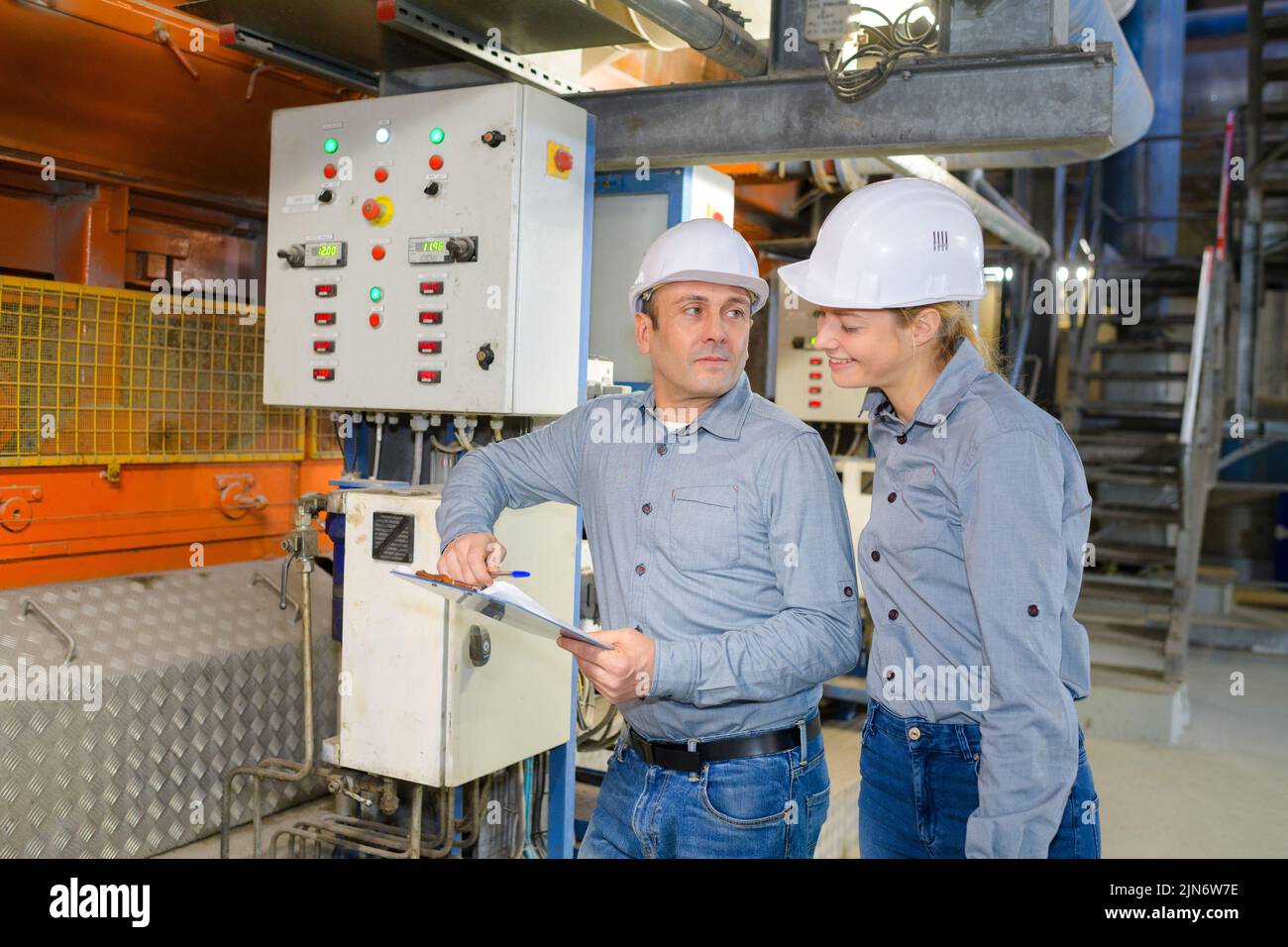 lavoratori che operano macchinari in fabbrica Foto Stock