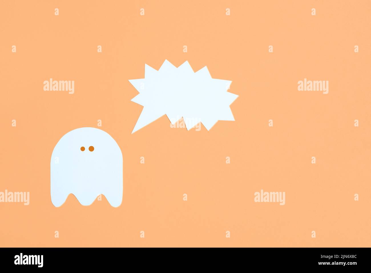 Design halloween alla moda, fantasma bianco carino con una bolla vocale vuota urlante su sfondo color arancio pastello, composizione minimale con spazio di copia. Foto Stock