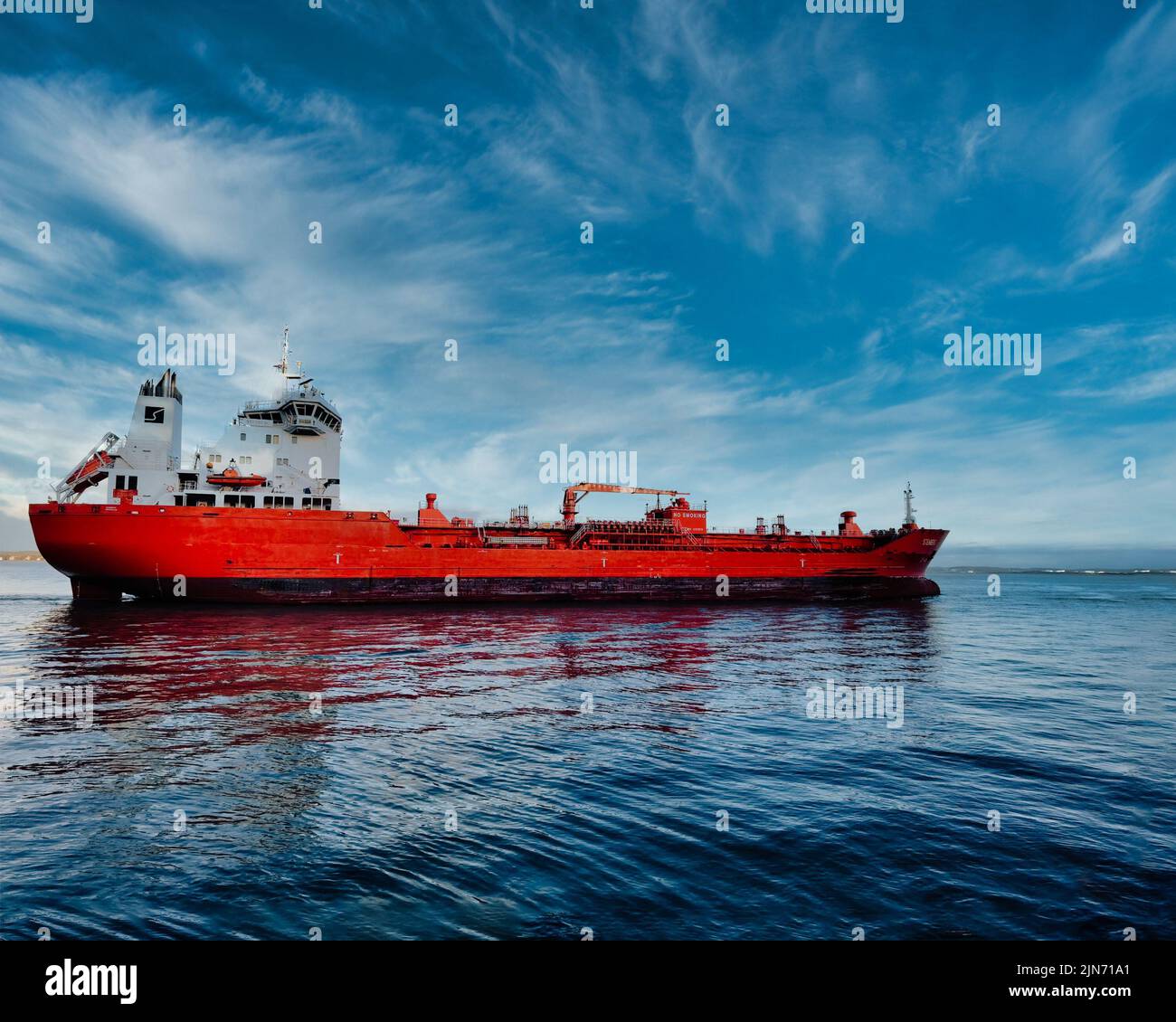 Una grande nave rossa sul fiume Mersey si adagiò contro il cielo blu e l'acqua Foto Stock