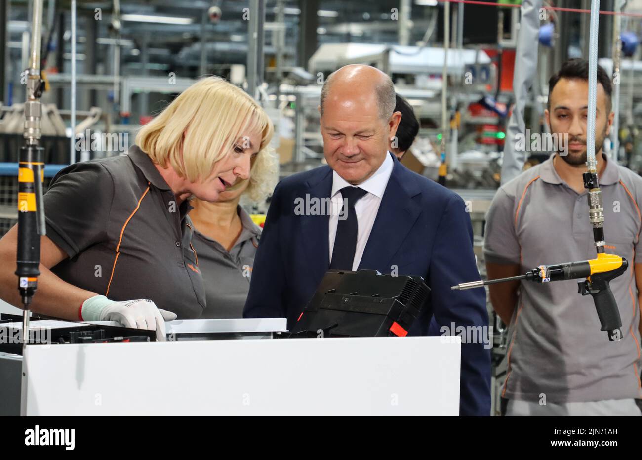 23 maggio 2022, Hessen, Allendorf (Eder): Il cancelliere tedesco OLAF Scholz (SPD) avvita l'ultima vite in una pompa di calore sotto la guida di un dipendente Viessmann. Scholz ha appreso informazioni sulle pompe di calore e sulle soluzioni per il clima verde presso l'azienda a conduzione familiare Viessmann. Foto: Nadine Weigel/dpa Foto Stock