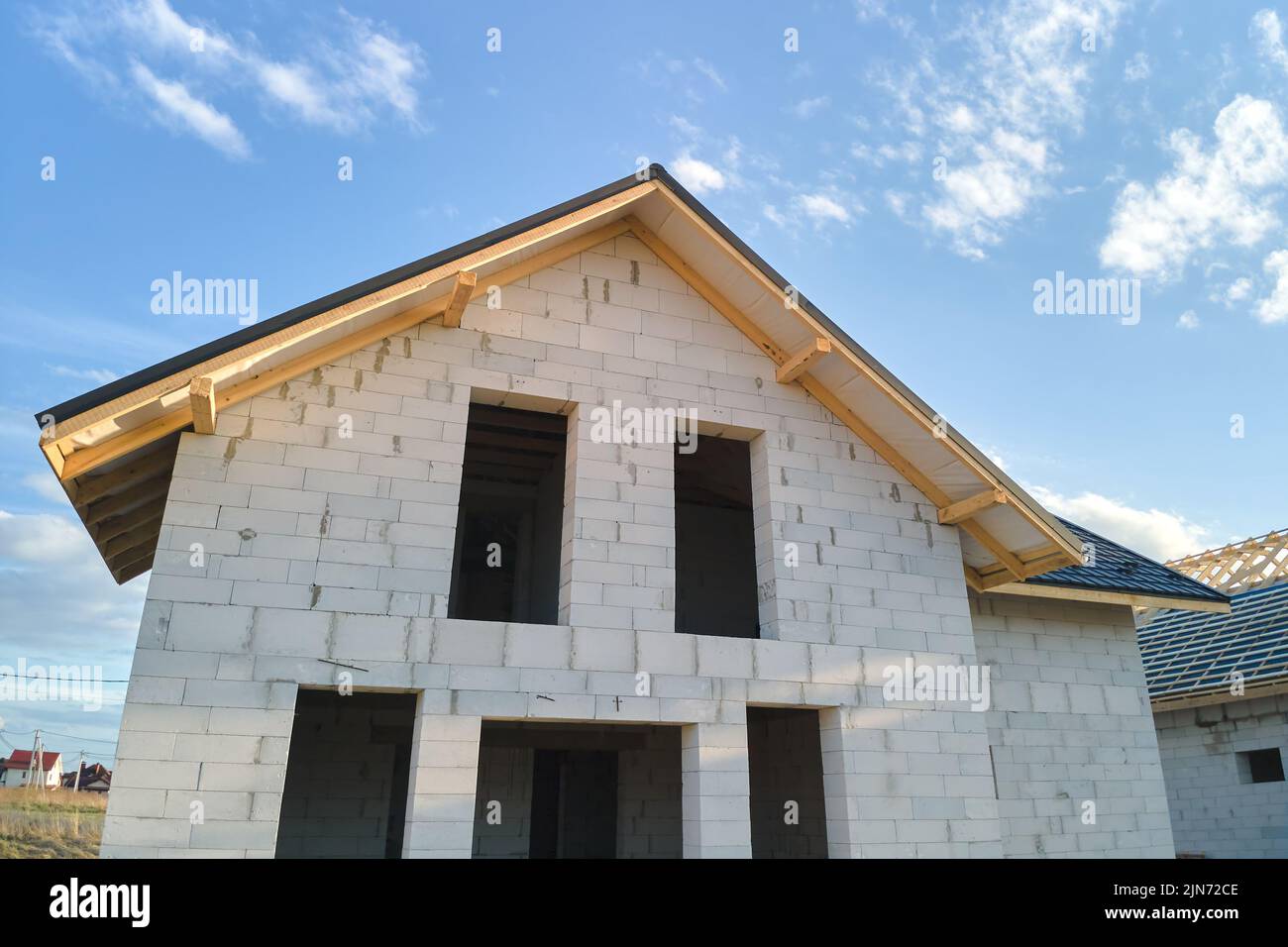 Vista aerea di casa incompiuta con pareti in calcestruzzo leggero aerato e telaio del tetto in legno rivestito con piastrelle metalliche in costruzione Foto Stock
