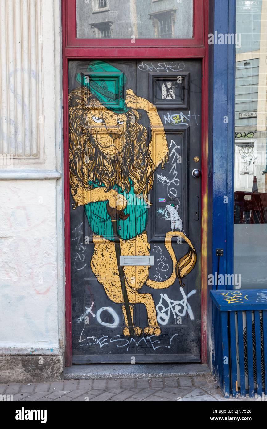Leone dipinto su una porta - Arte di strada Contemporanea - graffiti urbani a Stokes Croft, Bristol, Inghilterra, Regno Unito Foto Stock