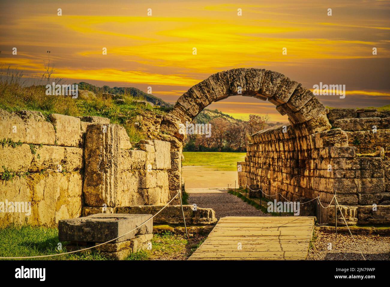 Ingresso stadio - muri in pietra e arco che entrano nel campo dove i primi giochi di Pah Hellenic si sono svolte a Olympia Grecia al tramonto. Foto Stock