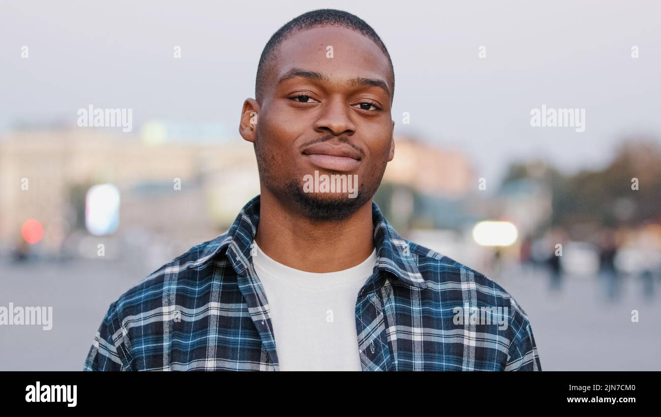 Chiamami segno. Simbolo di chiamata. Uomo afro-americano positivo guardando la macchina fotografica giocoso flirting ragazzo in città tenendo il telefono mano gesto vicino orecchio Foto Stock