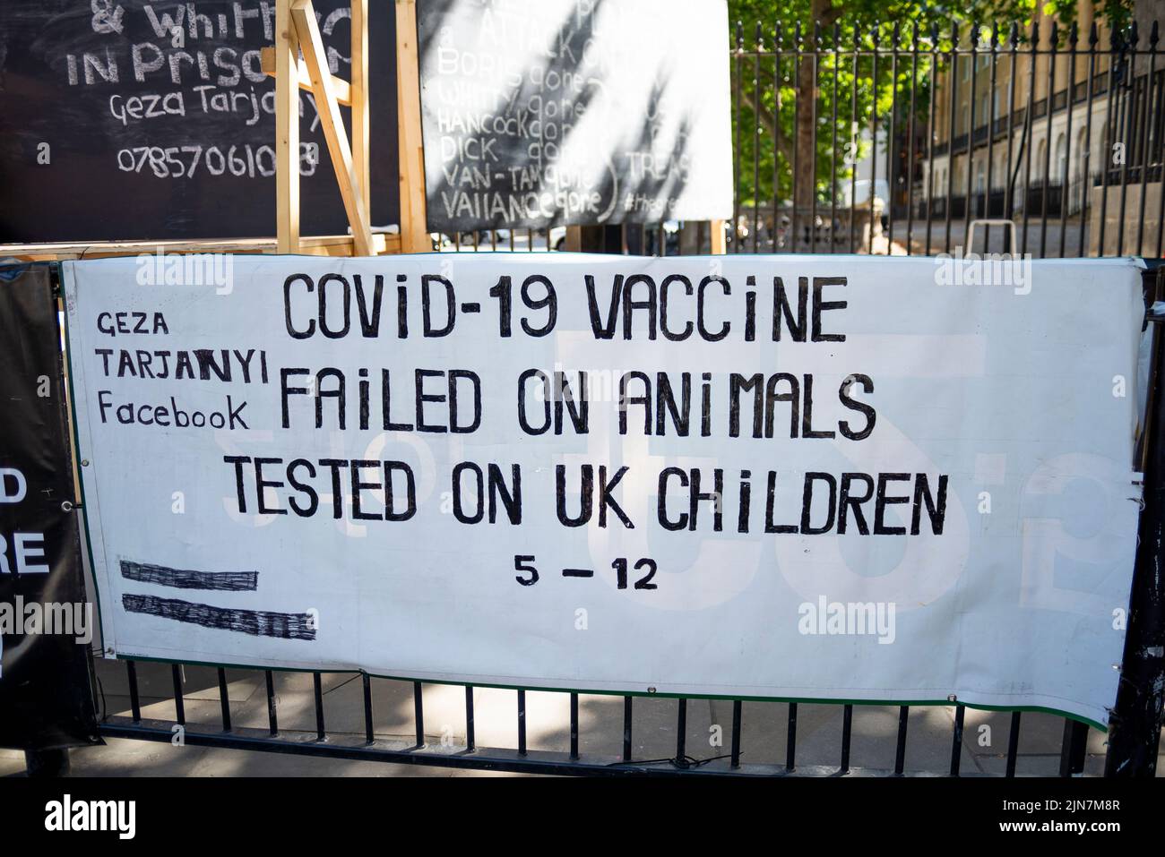 Il banner di protesta della teoria della cospirazione di Covid 19 si trova a Whitehall, Westminster, Londra, Regno Unito. Vaccino fallito su animali, testato su bambini britannici Foto Stock