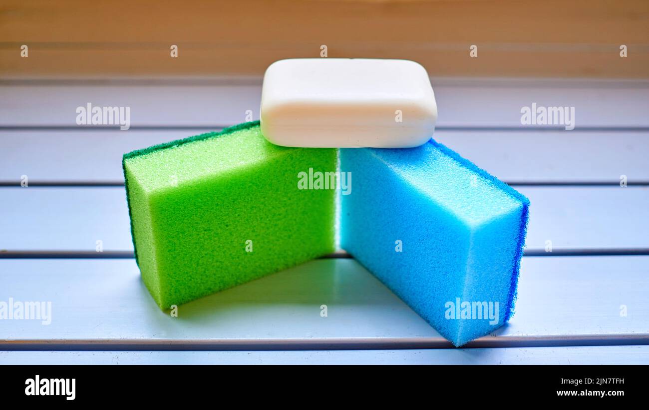 Set per lavaggio e pulizia.spugna blu verde e sapone bianco Foto Stock