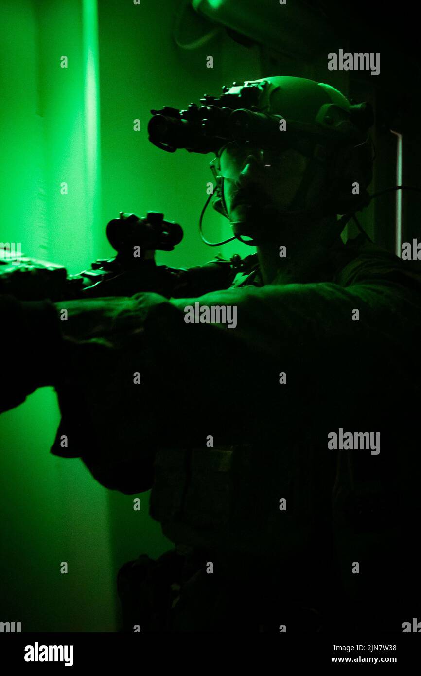 U.S. Marine Sgt. Juan Martinez, un sergente platoon con Battaglione Landing Team 2/5, 31st Marine Expeditionary Unit, si muove attraverso un corridoio all'interno della base mobile di spedizione USS Miguel Keith (ESB-5) durante una visita di ricerca bordo e sequestro esercizio nel Mare delle Filippine, 7 agosto 2022. Il MEU del 31st mantiene la capacità di sequestrare e sgommare le navi mentre sono in mare per proteggersi e allearsi nella regione Indo-Pacific. Il MEU 31st opera a bordo di navi del Tripoli Amphibious Ready Group nell'area Fleet 7th per migliorare l'interoperabilità con alleati e partner e servire come Foto Stock