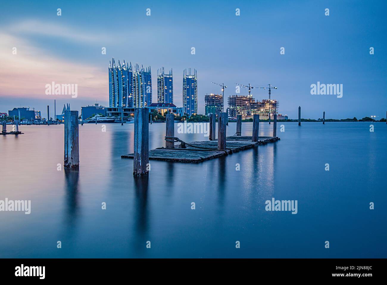 Lo skyline di Giacarta si affaccia dalla baia con pali di legno, Indonesia Foto Stock