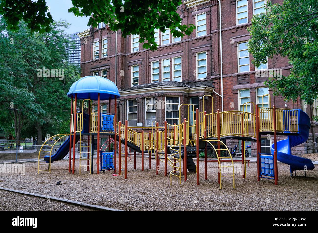 Attrezzature per il parco giochi della scuola e trucioli di legno a terra per la sicurezza Foto Stock