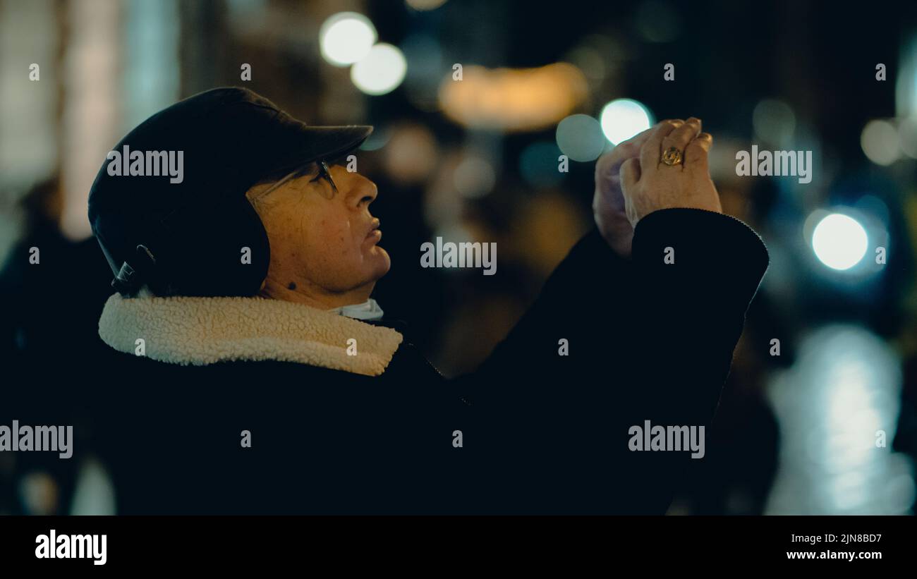 Un vecchio che fotografa con uno smartphone per strada, Rennes, Francia Foto Stock