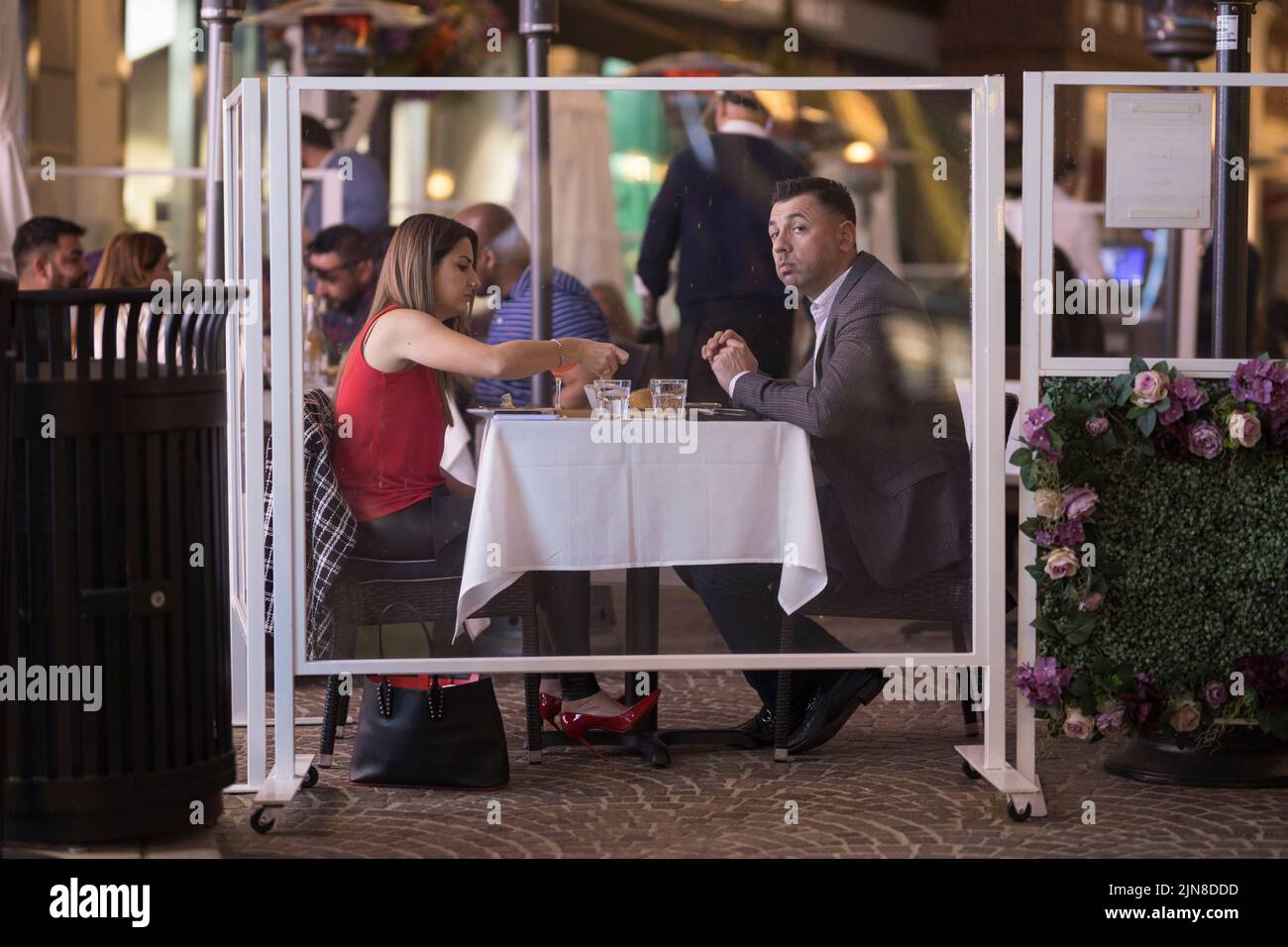 Un paio di cene all'aperto al ristorante 208 Rodeo di Beverly Hills. Divisori trasparenti e distensione sociale minimizzano il rischio di malattie. Foto Stock