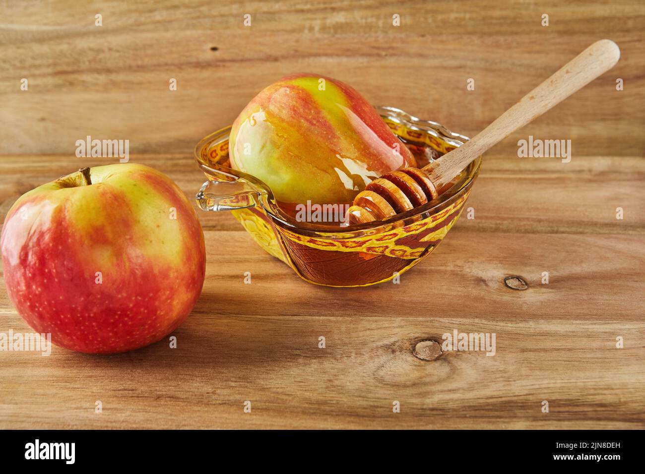 Rosh hashanah - concetto ebraico di vacanza di nuovo anno. Ciotola in forma di mela con miele e mele - simboli tradizionali della festa su legno Foto Stock