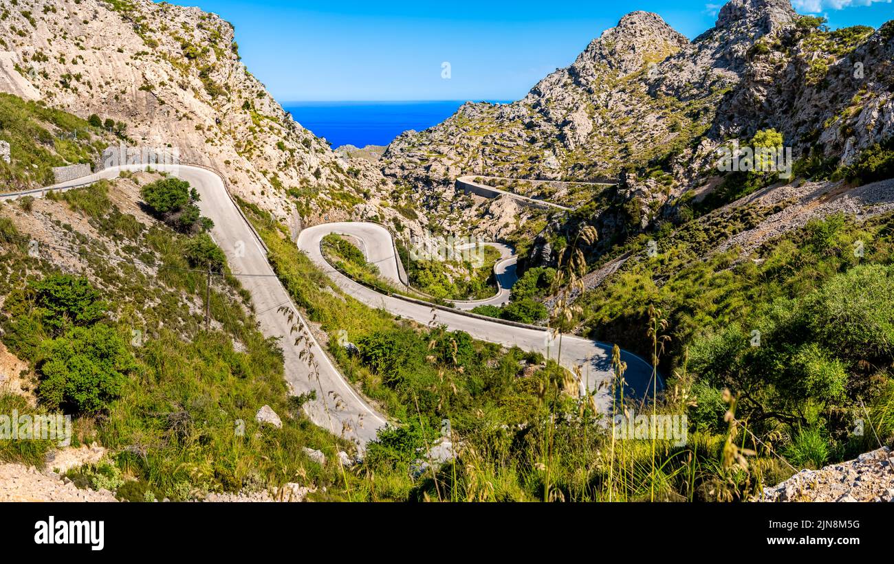 Mallorca tortuosa strada ma-2141 che conduce attraverso terreni estremi in una valle di Serra de Tramuntana montagne, curvando in stretta serpentina giù. Foto Stock