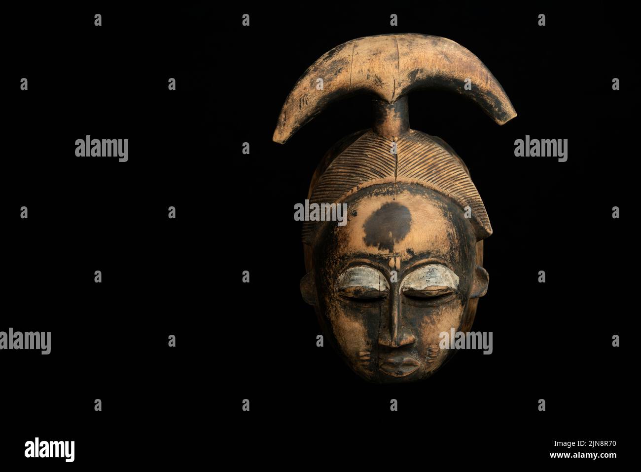 Tradizionale maschera africana di legno su sfondo nero Foto Stock