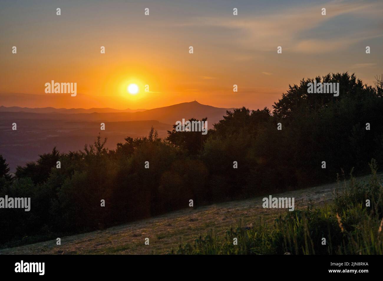 Tramonto sulle montagne, foresta e prato, collina Jested all'orizzonte, serata sulla collina Kozakov, Paradiso ceco, repubblica Ceca. Foto Stock