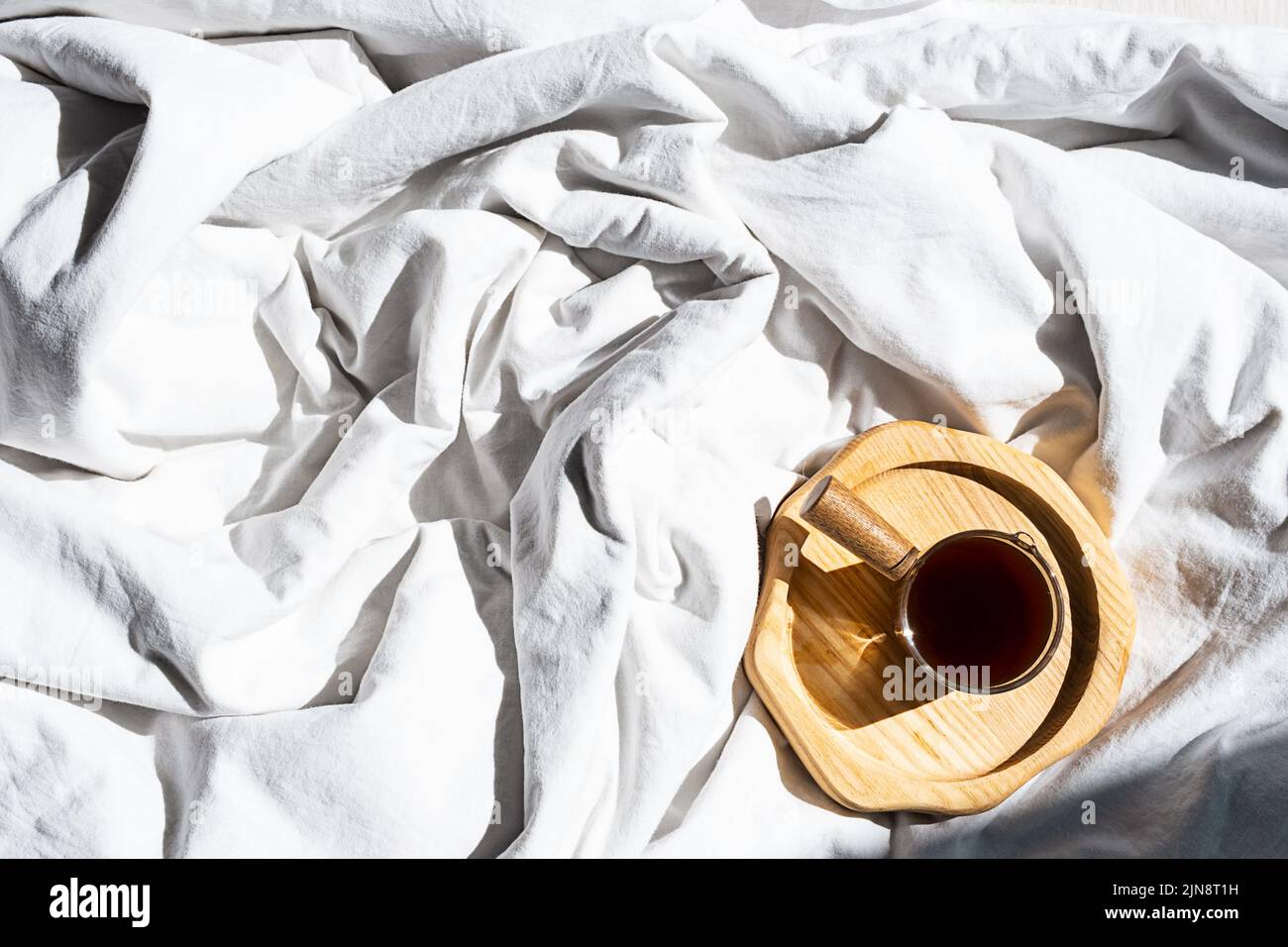 Ambiente accogliente e accogliente con una tazza di caffè a letto. Concetto di mattina. Foto Stock