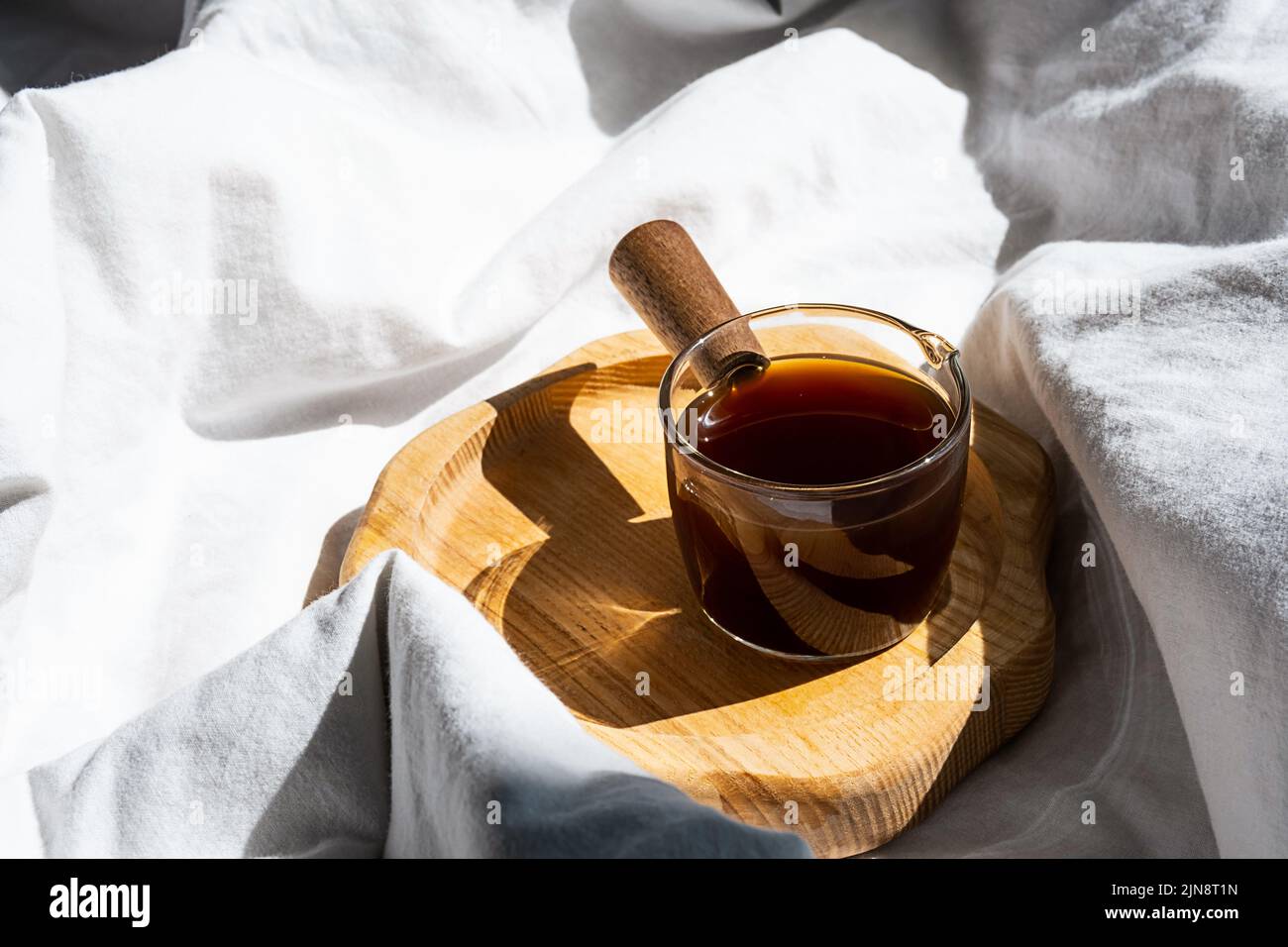 Ambiente accogliente e accogliente con una tazza di caffè a letto. Concetto di mattina. Foto Stock