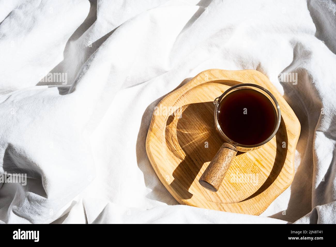 Ambiente accogliente e accogliente con una tazza di caffè a letto. Concetto di mattina. Foto Stock