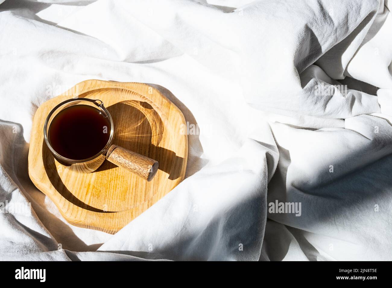 Ambiente accogliente e accogliente con una tazza di caffè a letto. Concetto di mattina. Foto Stock