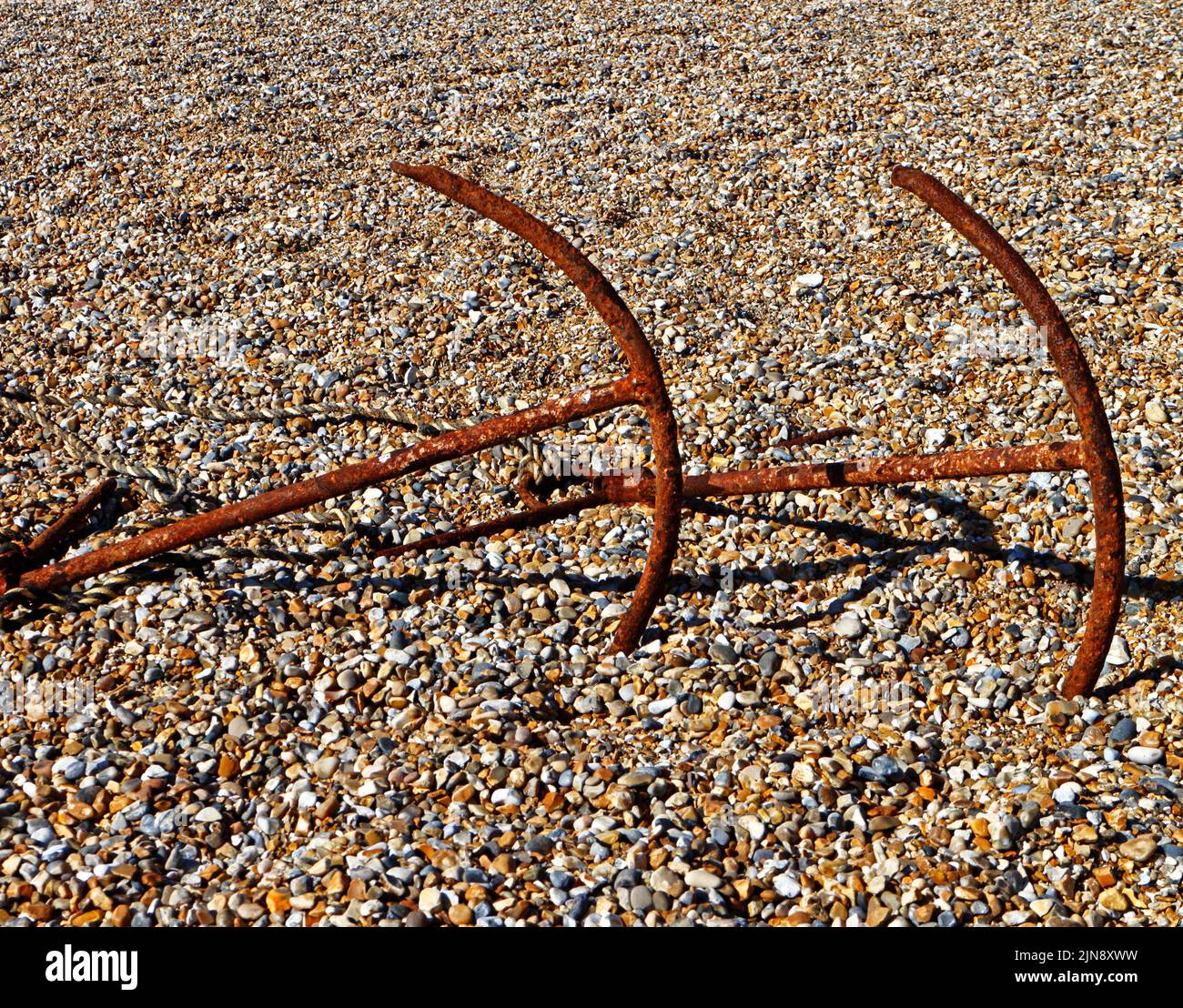 Due ancore immagazzinate con attrezzatura da pesca commerciale sulla spiaggia di ciottoli nel Nord Norfolk a Cley-next-the-Sea, Norfolk, Inghilterra, Regno Unito. Foto Stock