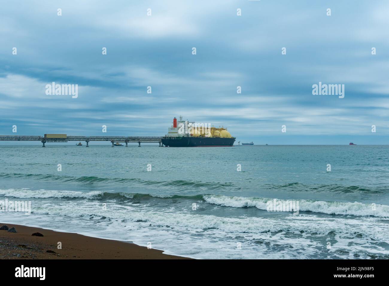 Nave cisterna per il trasporto di gas naturale liquefatto durante il carico presso un terminale offshore GNL Foto Stock