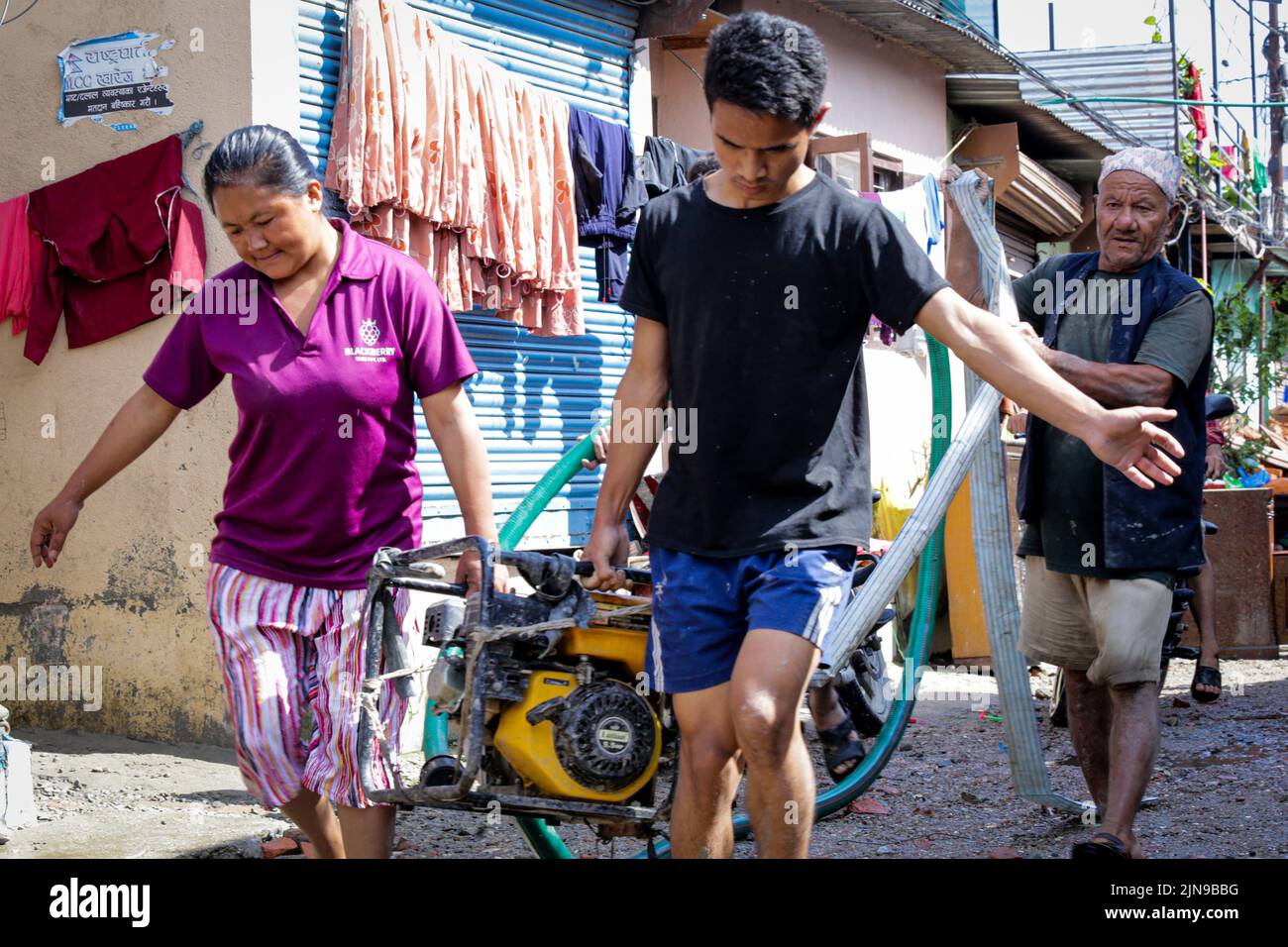 Il 10 agosto 2022 a Kathmandu, Nepal. La gente trasporta la pompa dell'acqua per pompare le acque accmulate nelle case colpite dall'alluvione vicino agli insediamenti del fiume a causa della pioggia pesante. (Foto di Abhishek Maharjan/Sipa USA) Foto Stock