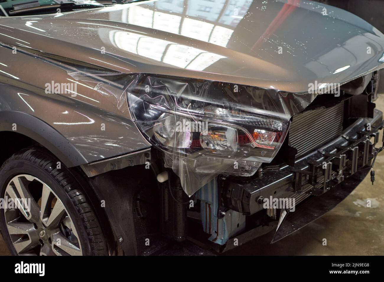 Installazione di una vernice protettiva e di una pellicola trasparente di vernice sulla vettura. Pellicola in poliuretano PPF per proteggere la vernice da pietre, segni e scorra Foto Stock
