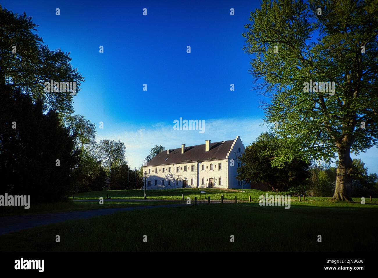 Una vista aerea del castello di Baruth circondato da alberi in crescita sotto il cielo blu luminoso Foto Stock